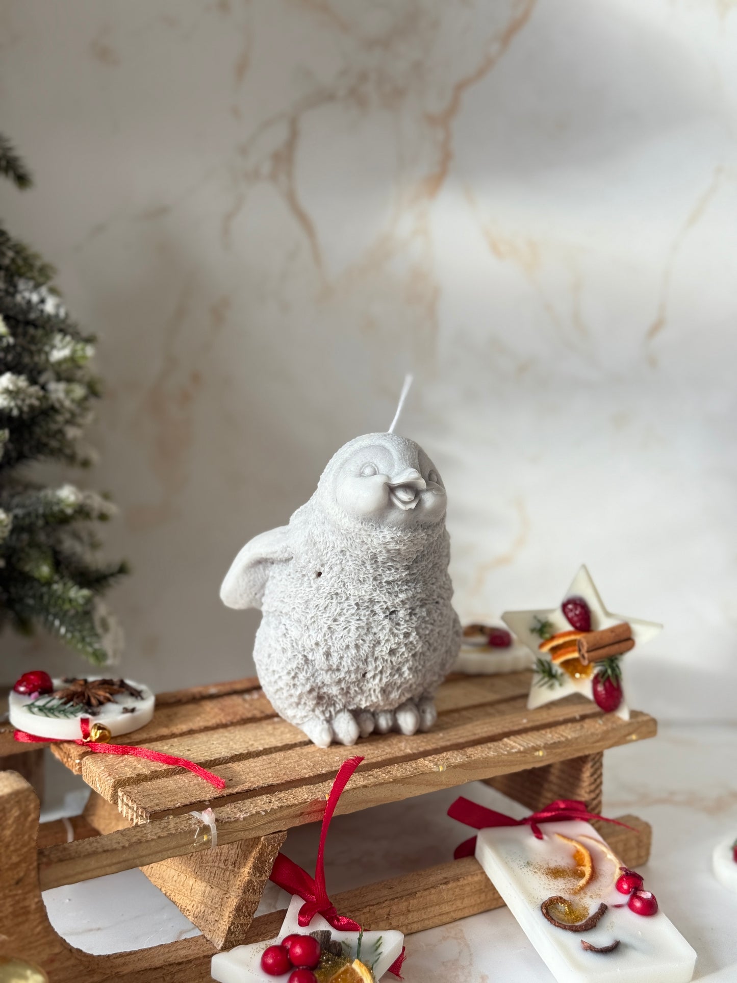 Decorative scene with a small gray creature on a wooden platform against a marble wall.